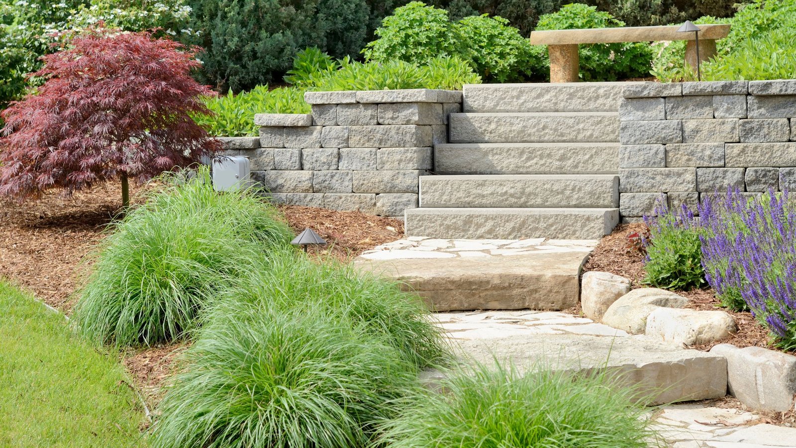 a retaining wall with stars in between surrounded by plants